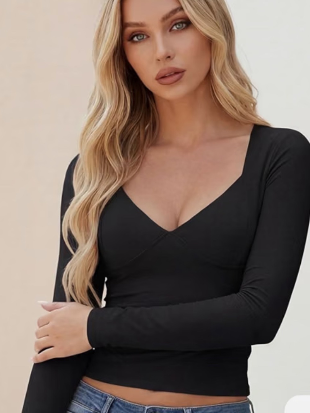 Sleek black V-neck long sleeve top with a flattering fitted silhouette. Smooth s